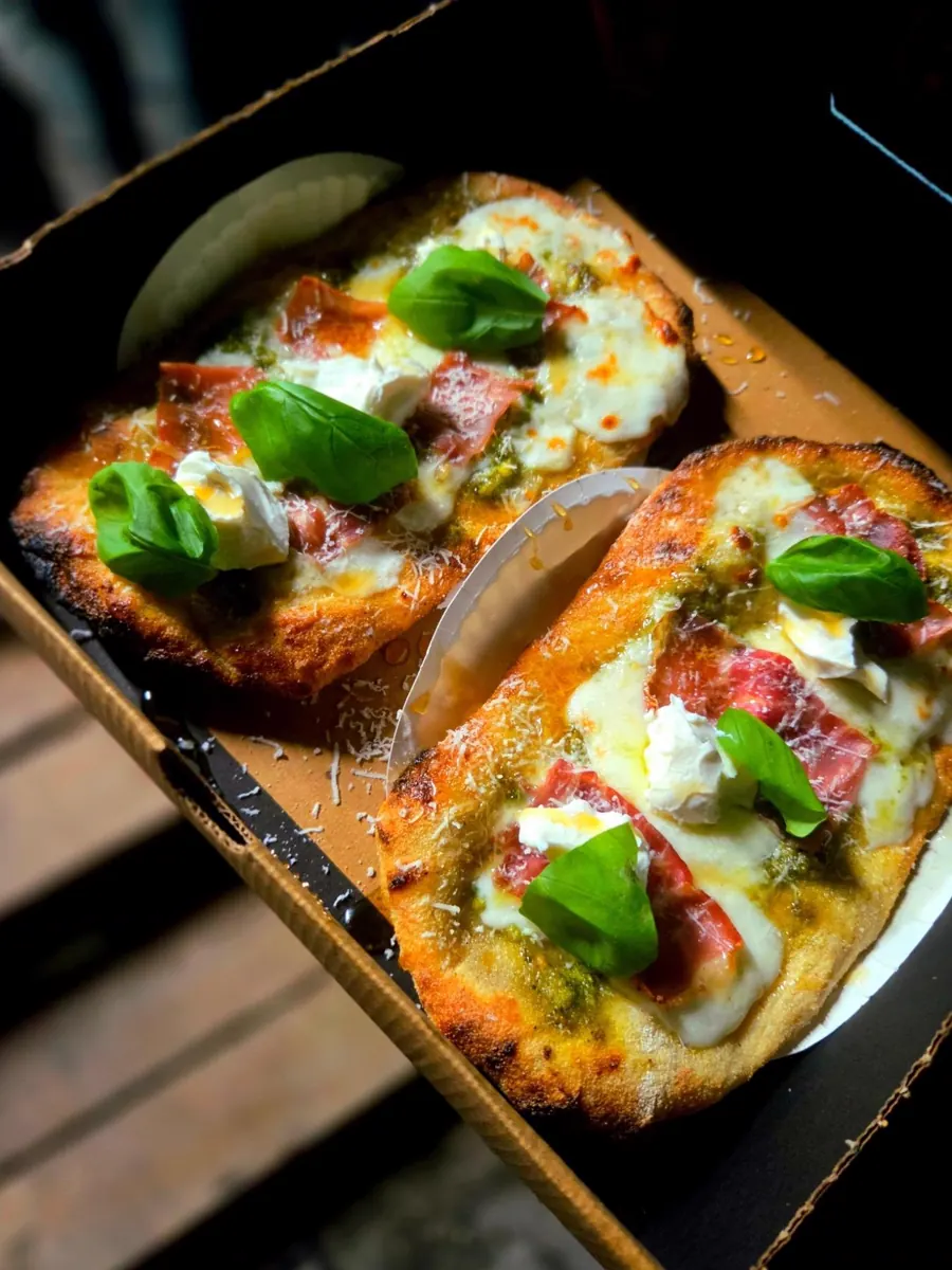 Dos pizzas de La Ricetta con pesto, prosciutto y albahaca en su caja